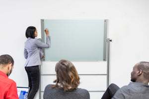 Easel Stand For Glass Dry-Erase Boards (Stand Only Does Not Include Glass Board). Locking wheels and mobile.  Shown being used during a presentation for teaching during classroom. 